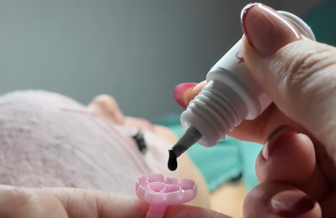 Professionel eyelash extension-lim påføres i en roseformet ring under vippestyling hos Beautybydau.