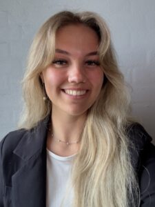 Smilende portræt af klinikchefen hos BeautyByDau iført blazer. Professionelt og imødekommende udtryk, der repræsenterer tryghed og kvalitet i klinikken.