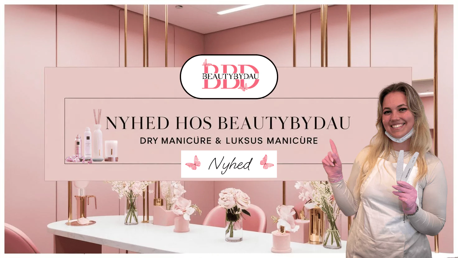 "Promobillede fra BeautyByDau med teksten 'Nyhed hos BeautyByDau – Dry Manicure & Luksus Manicure'. En glad medarbejder i handsker peger op mod skiltet, omgivet af lyserøde nuancer, blomster og produkter fra Rituals."
